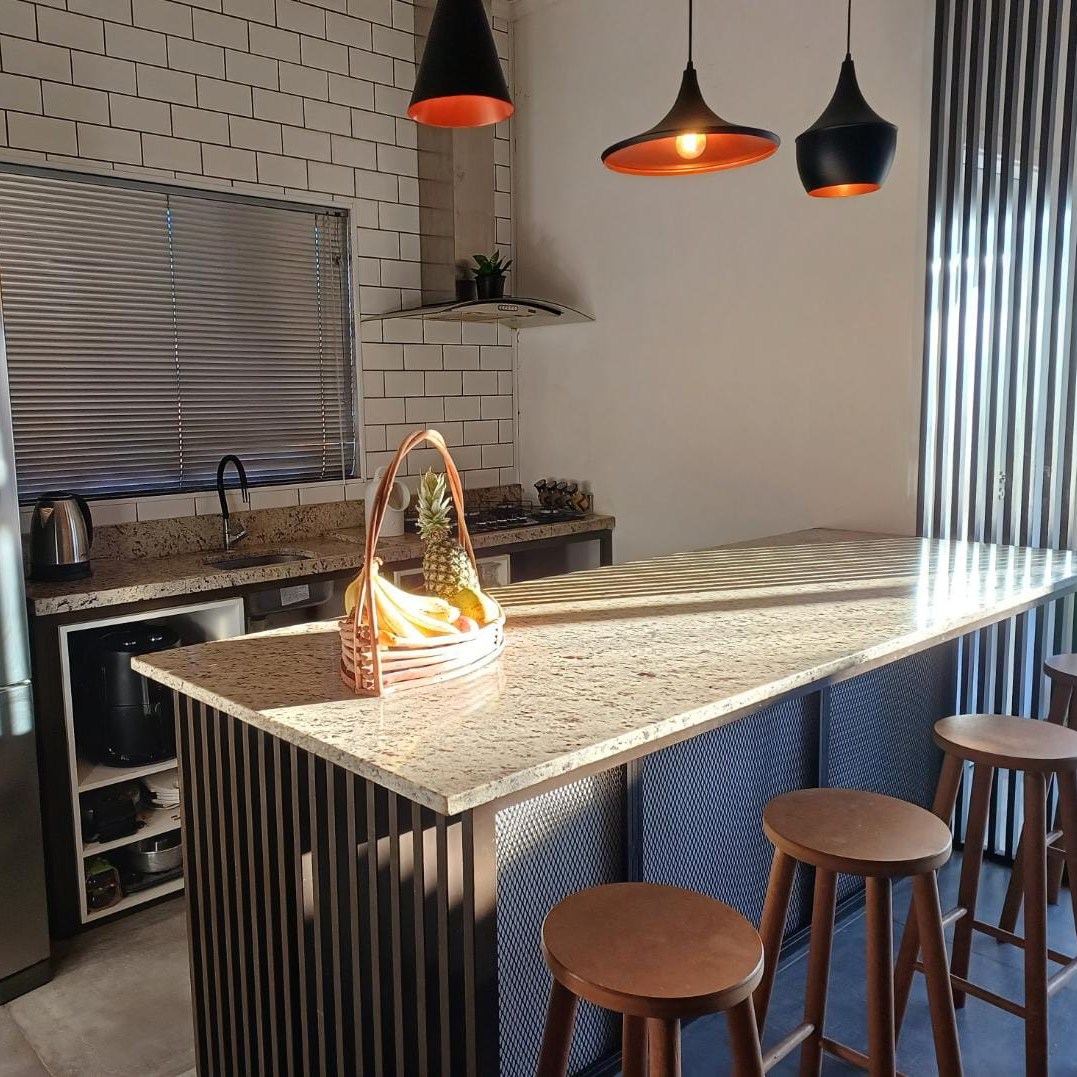 Imagem de uma cozinha moderna com uma grande ilha central e bancos ao redor